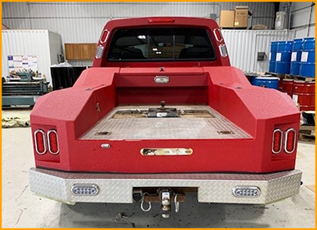 Red work truck bed sprayed with GatorHyde and topcoated with red urethane paint to match truck cab.