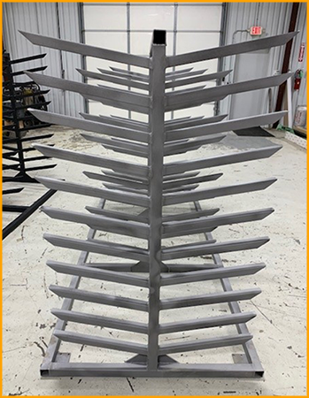  Steel racks are sanded and primed for polyurea coating.